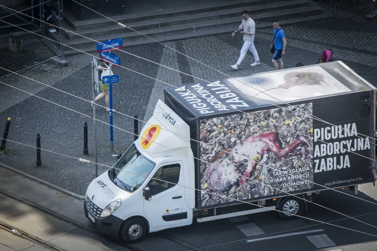 Truck covered with anti-abortion billboard graphics at a city intersection